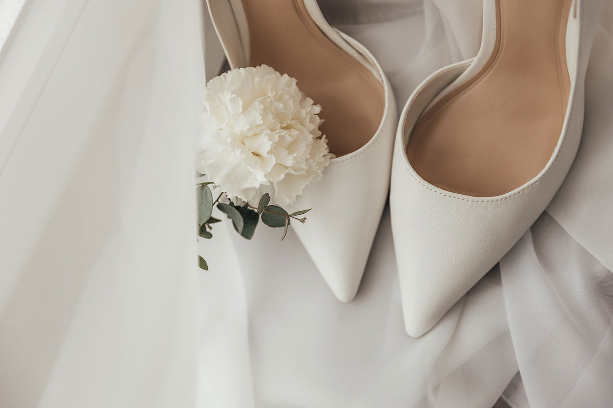 Weiße Brautschuhe mit Schleier und weißer Blume
