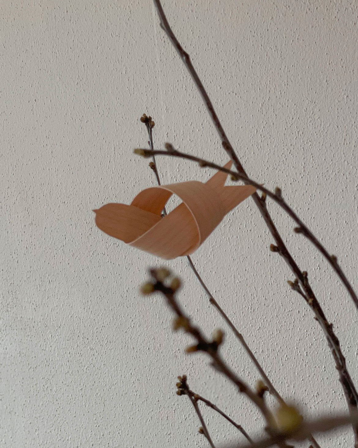 Selbstgebastelter Vogel aus Holzfurnier zum Aufhängen an Zweige