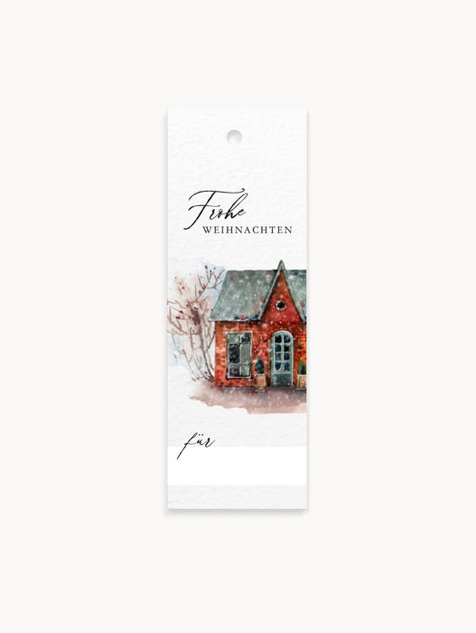 Geschenkanhänger im 8er Set mit rotem Haus in Winterlandschaft, „Frohe Weihnachten“ Aufschrift, Empfängerzeile und blanko Rückseite mit kleinem Logo.
