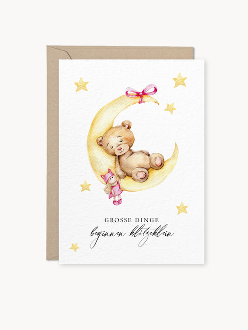 Grußkarte mit Bären auf gelbem Mond und der Aufschrift „Große Dinge beginnen klitzeklein“, inklusive Kraftpapier-Umschlag, auf hellem Naturkarton gedruckt.