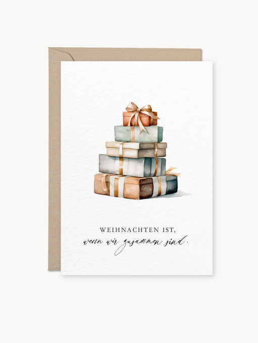 Mehrfarbige Grußkarte mit Aquarellmotiv von Geschenken und Schriftzug „Weihnachten ist, wenn wir zusammen sind.“, auf Naturkarton mit Kraftpapier-Umschlag