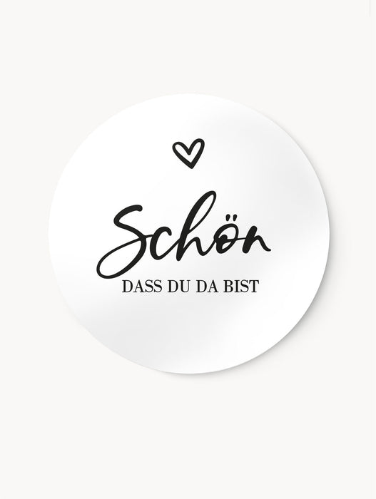 Aufkleber ‚Schön, dass du da bist‘ im Schwarz-Weiß Design, mit Herz im oberen Bereich, seidenmatt und wischfest. Erhältlich in 3 cm und 4 cm Durchmesser, perfekt für Geschenkverpackungen oder kreative DIY-Projekte.