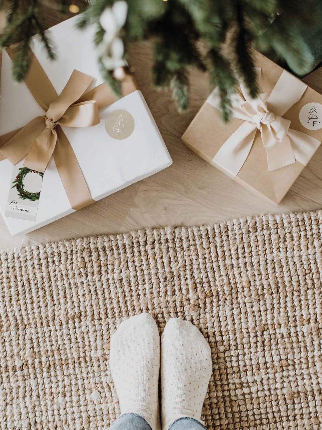 Stilvolle, nordisch verpackte Geschenke unter dem Weihnachtsbaum in natürlichen Farben mit Grünakzente