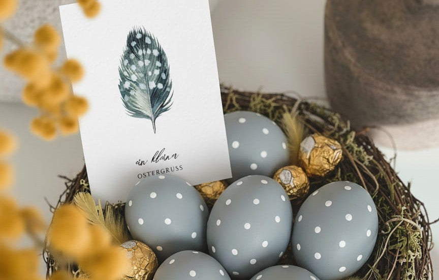 Stilvolles Osternest im Skandi Look mit graublauen Ostereiern und einer Osterkarte mit Aquarellmotiv