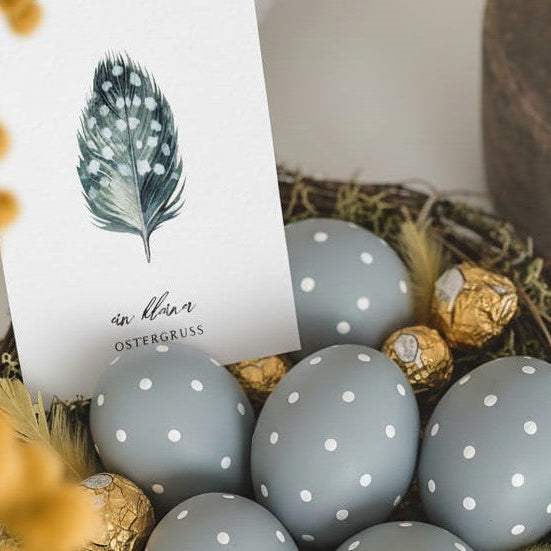 Stilvolles Osternest im Skandi Look mit graublauen Ostereiern und einer Osterkarte mit Aquarellmotiv