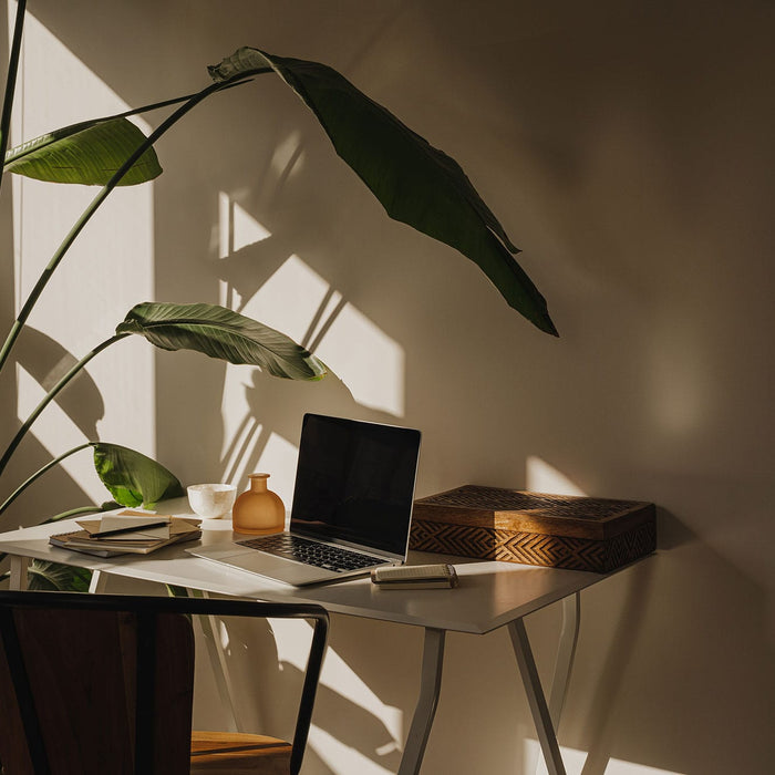 Stilvoller Arbeitsplatz für eine strukturierte Jahresplanung mit Laptop und Notizblöcken