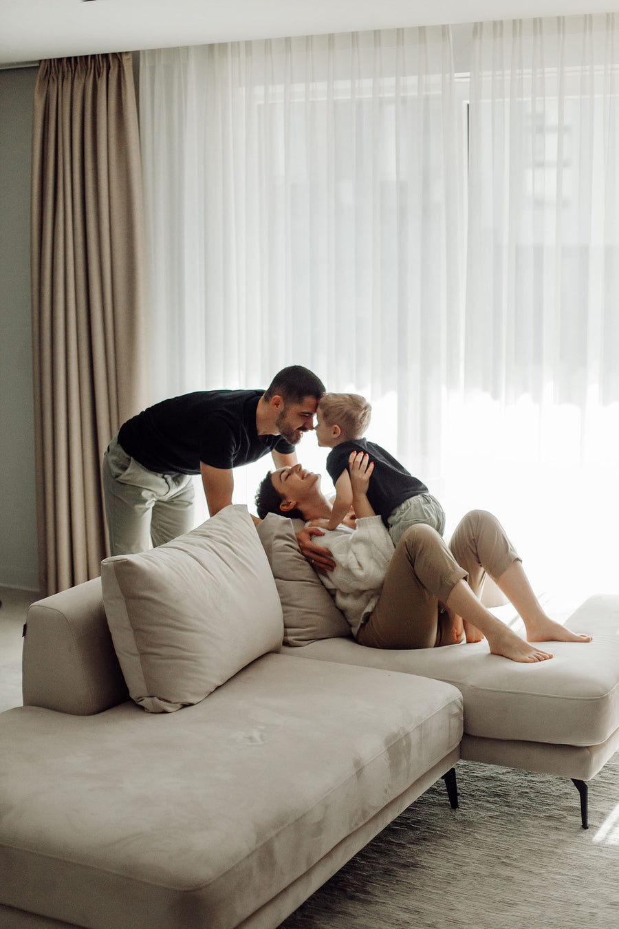 Familie genießt die Zeit zu dritt im harmonischen Wohnzimmer im skandinavischen Design.